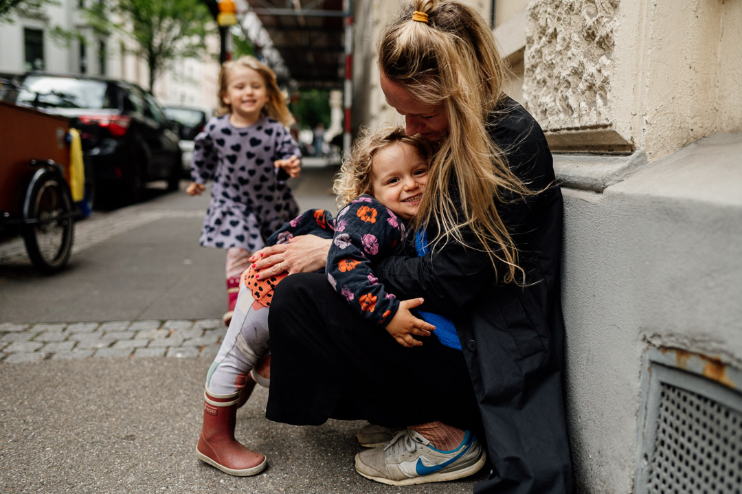 Kinder umarmen Mama auf der Straße