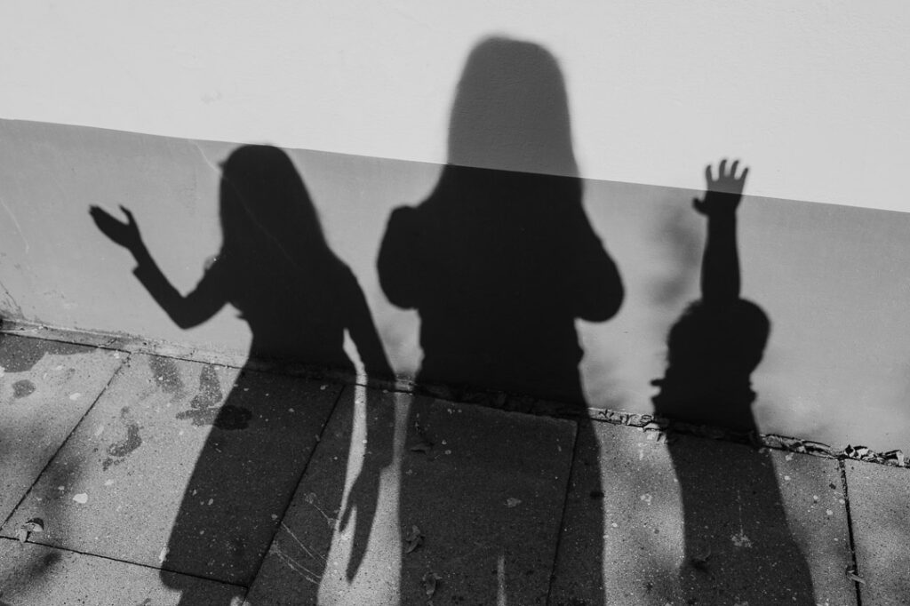 Schatten von drei Personen an Mauer
