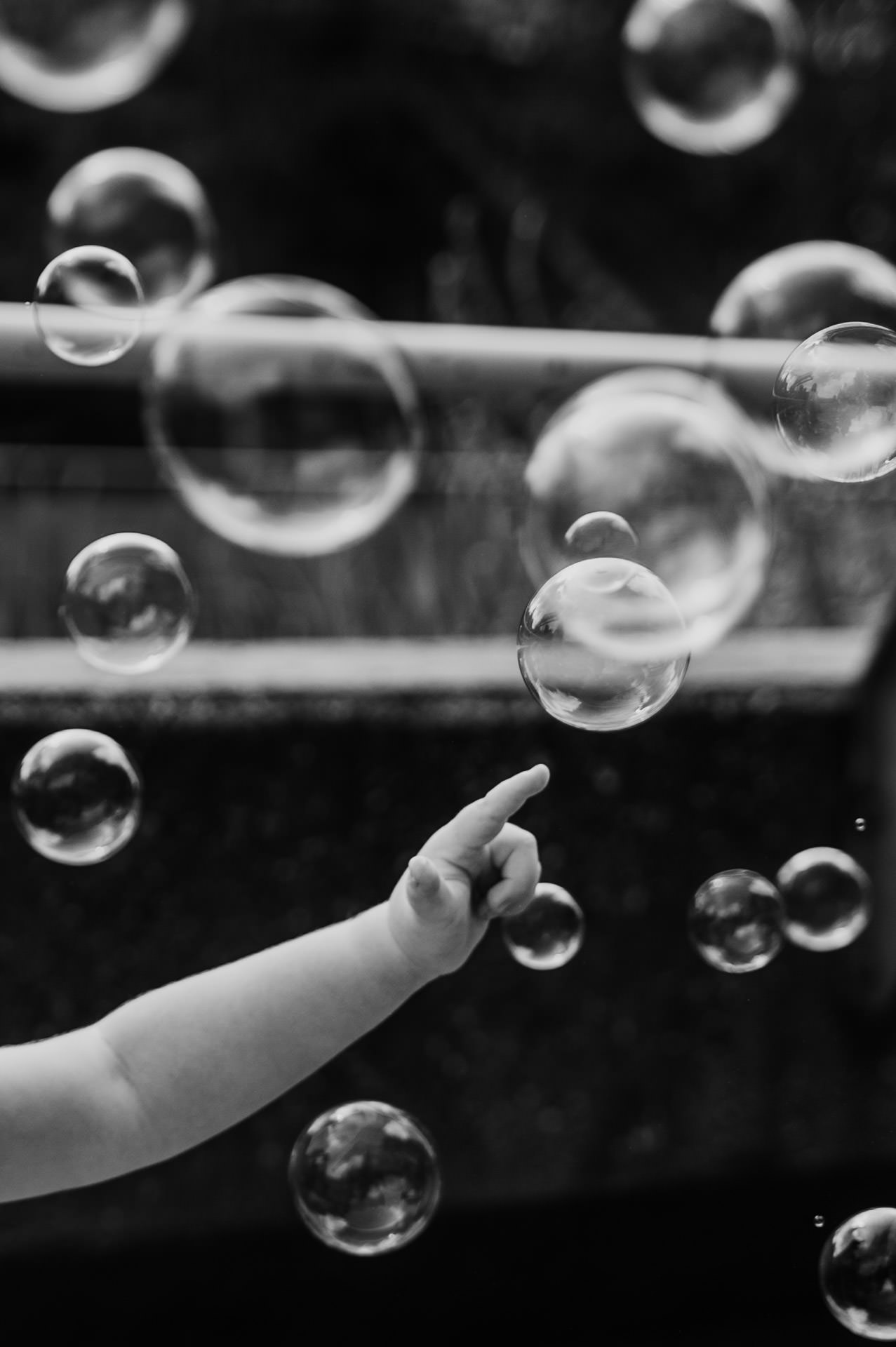 Kinderhand bringt Seifenblasen zum platzen