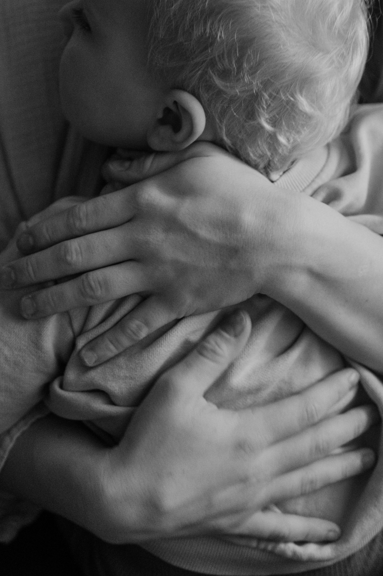 Hände halten ein Kleinkind fest umarmt